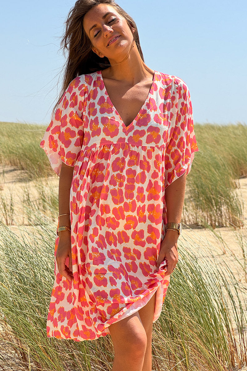 Ayelen - Vestido blanco de corte fluido con estampado de leopardo en rosa y naranja, cuello en V y mangas holgadas